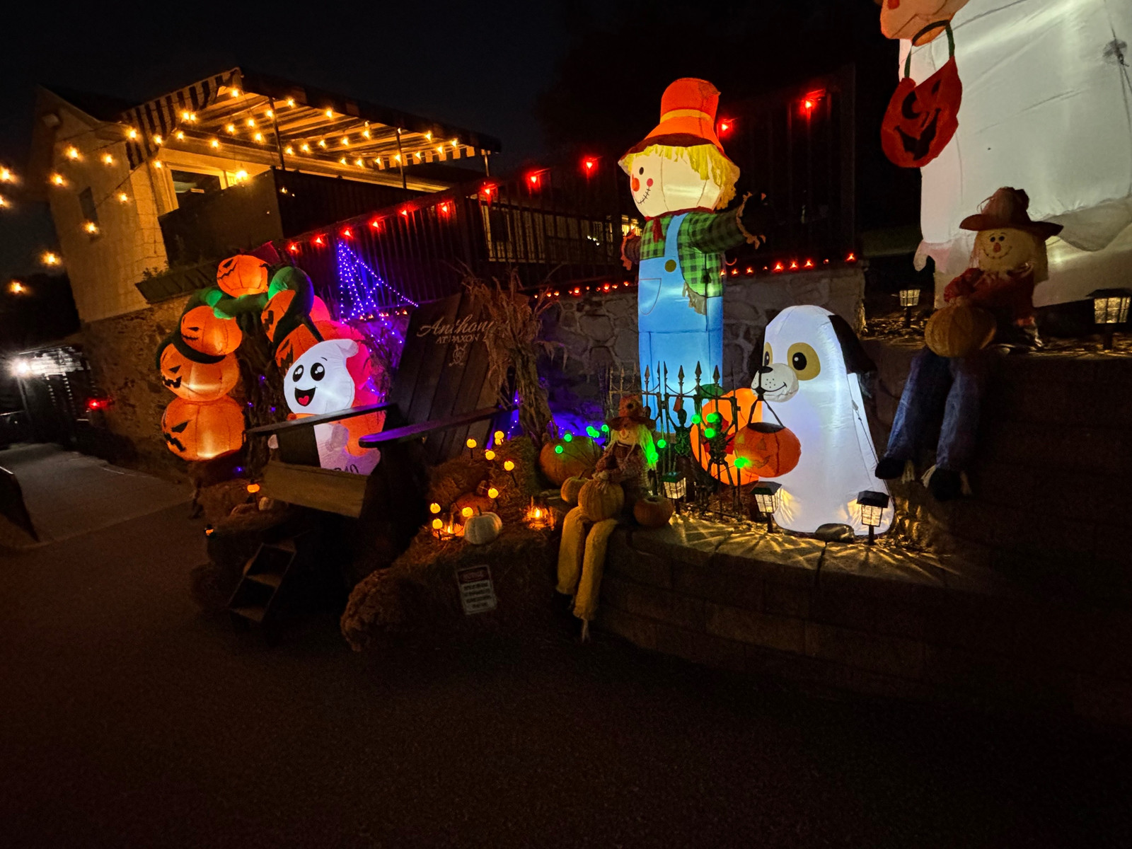 Glowing pumpkins, a friendly ghost, scarecrows and an Anthony’s at Paxon chair decorating the front of the restaurant at night