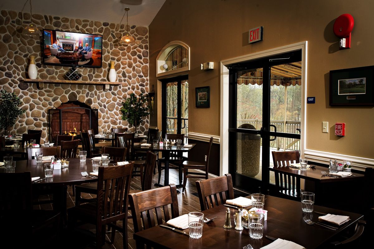 The dining room with its stone fireplace and doors opening onto the patio deck