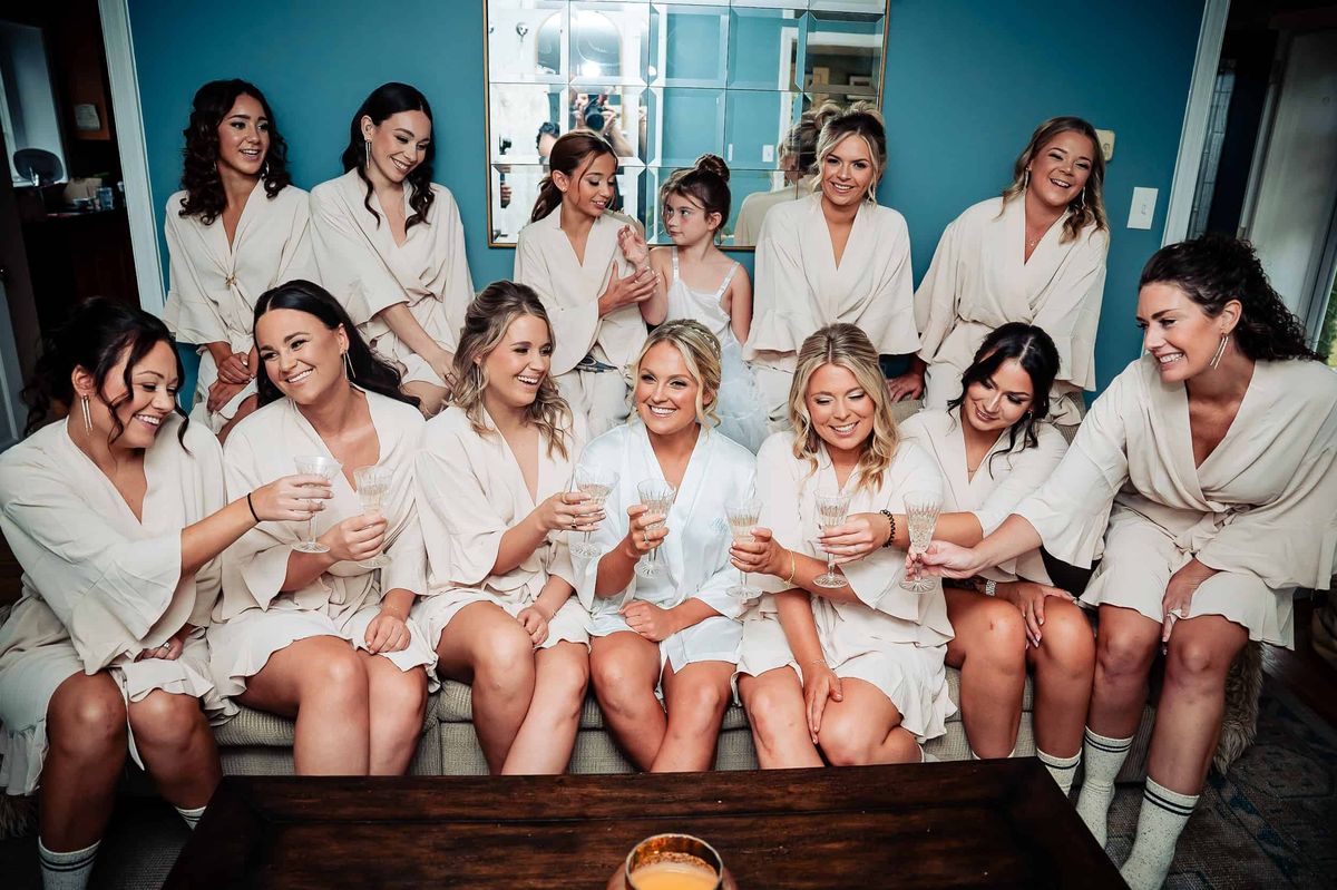 Bride and bridesmaids laughing together in robes