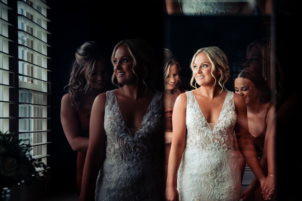Bride in her gown, framed in a mirror