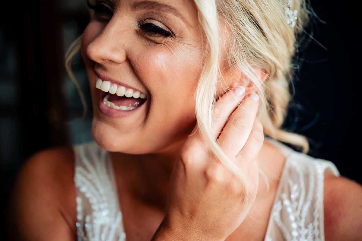 Bride laughing as she gets ready