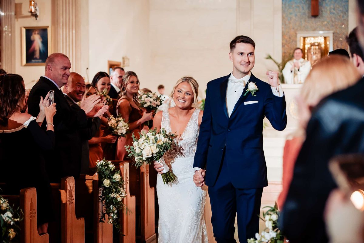 Newlyweds walking back up the aisle