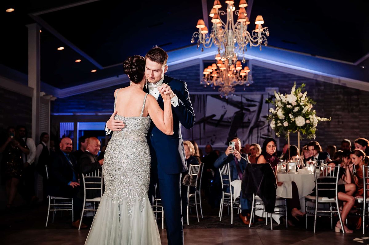 Mother–son dance beneath the chandeliers