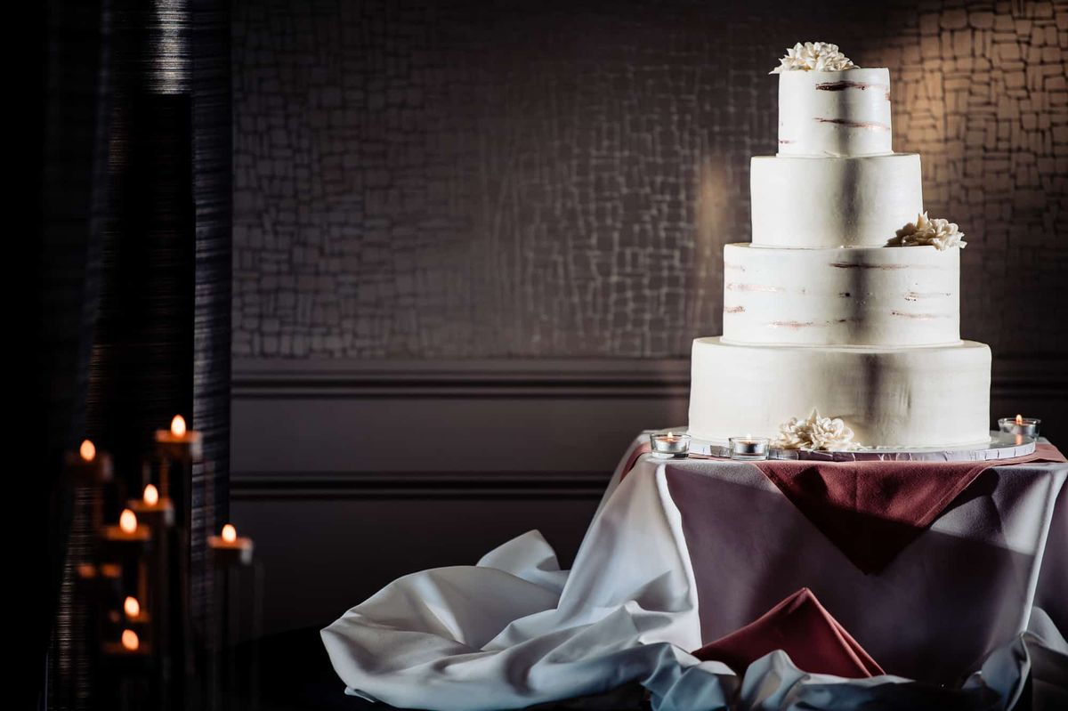 Tiered white wedding cake by candlelight