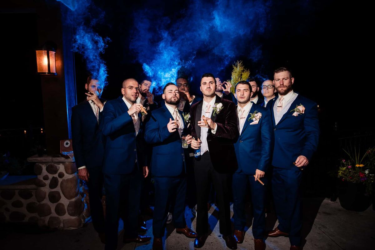 Groomsmen celebrating in a cloud of blue smoke